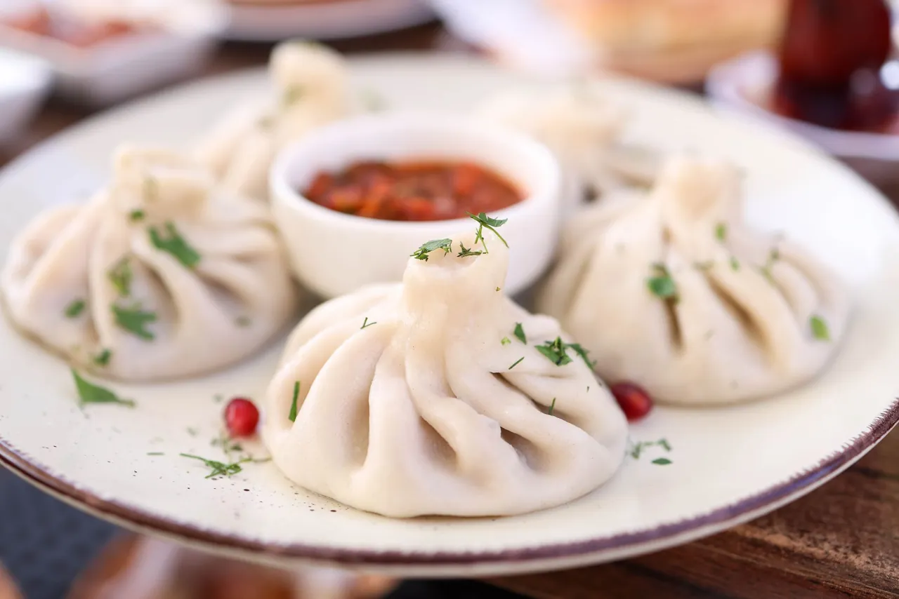 Plate of khinkali dumplings and khachapuri at a Georgian restaurant, Georgia