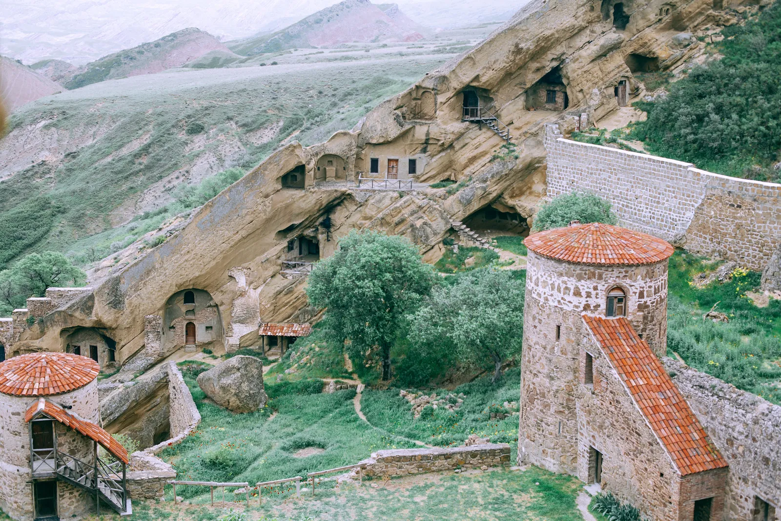 The Davit Gareja monastery complex from above, with cells carved into the sandstone cliff and the stone bell tower below