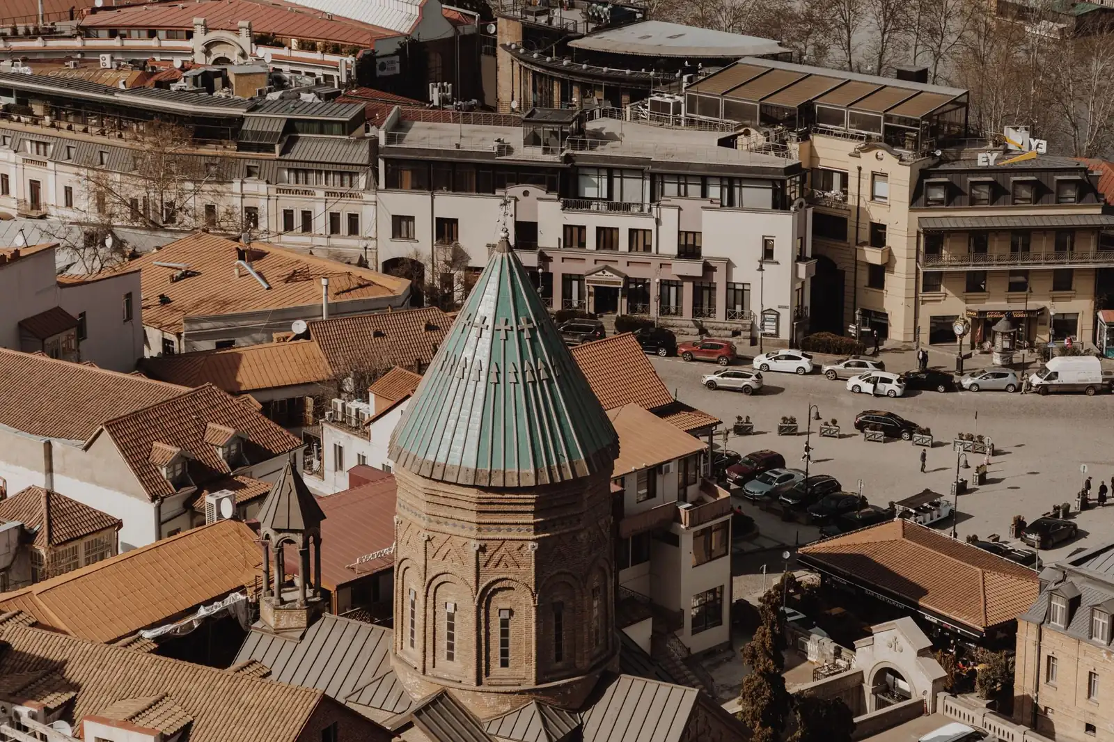 The tiled rooftops of Tbilisi old town with a church dome, seen from above in Georgia