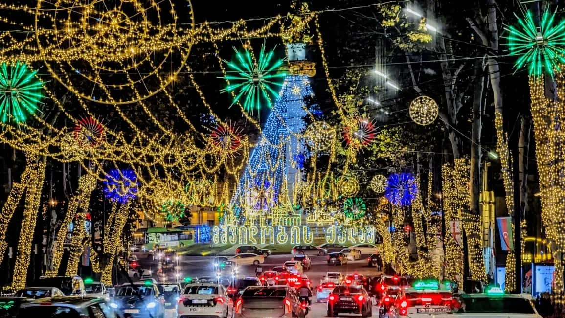 שוק חג המולד החגיגי בטביליסי בירת גאורגיה עם אורות, דוכנים מסורתיים ועץ אשוח מקושט בלב העונה הקרה