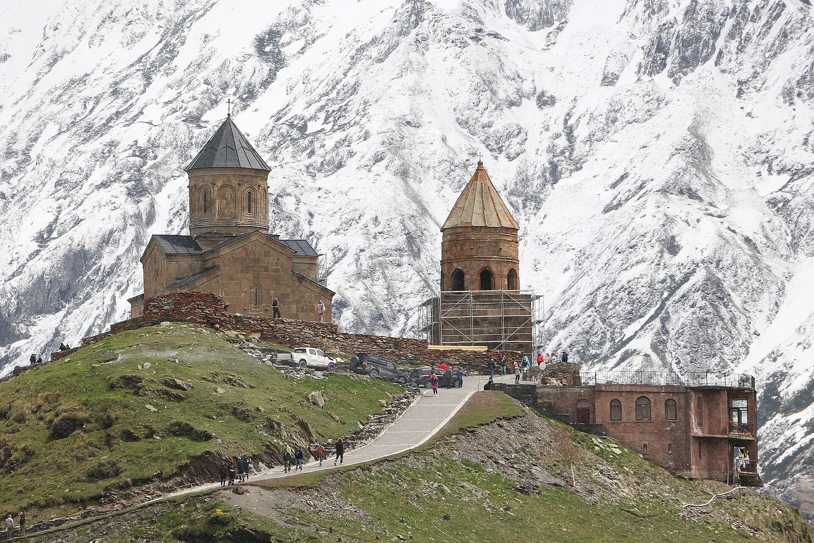 The Gergeti Trinity Church on its hill with snow covered mountains behind, Georgia