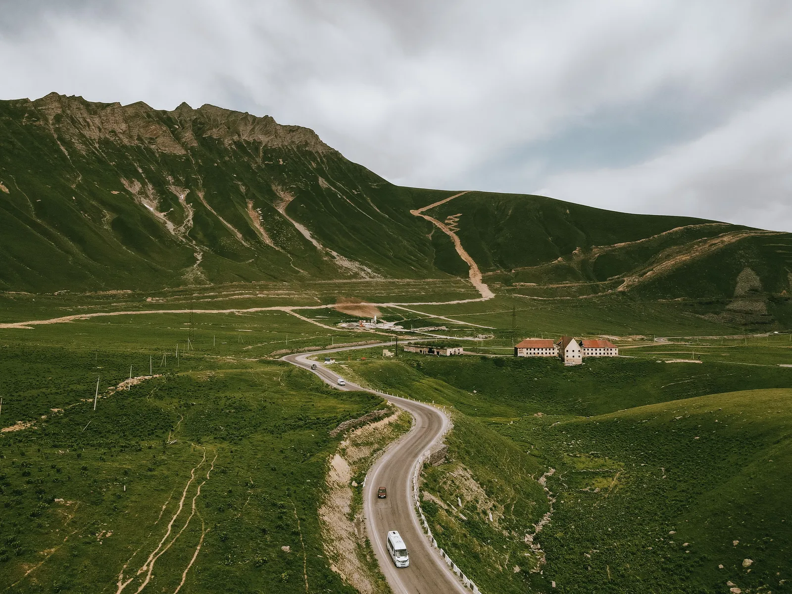 A road winding across a grassy mountain valley