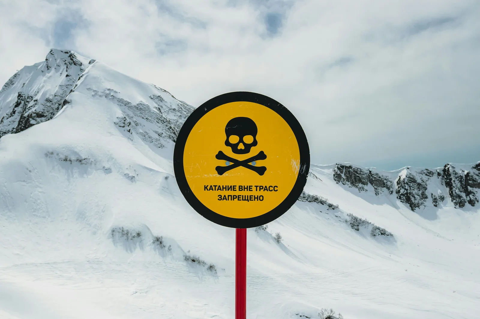 A warning sign on a snowy mountainside marking a closed off piste area in Georgia