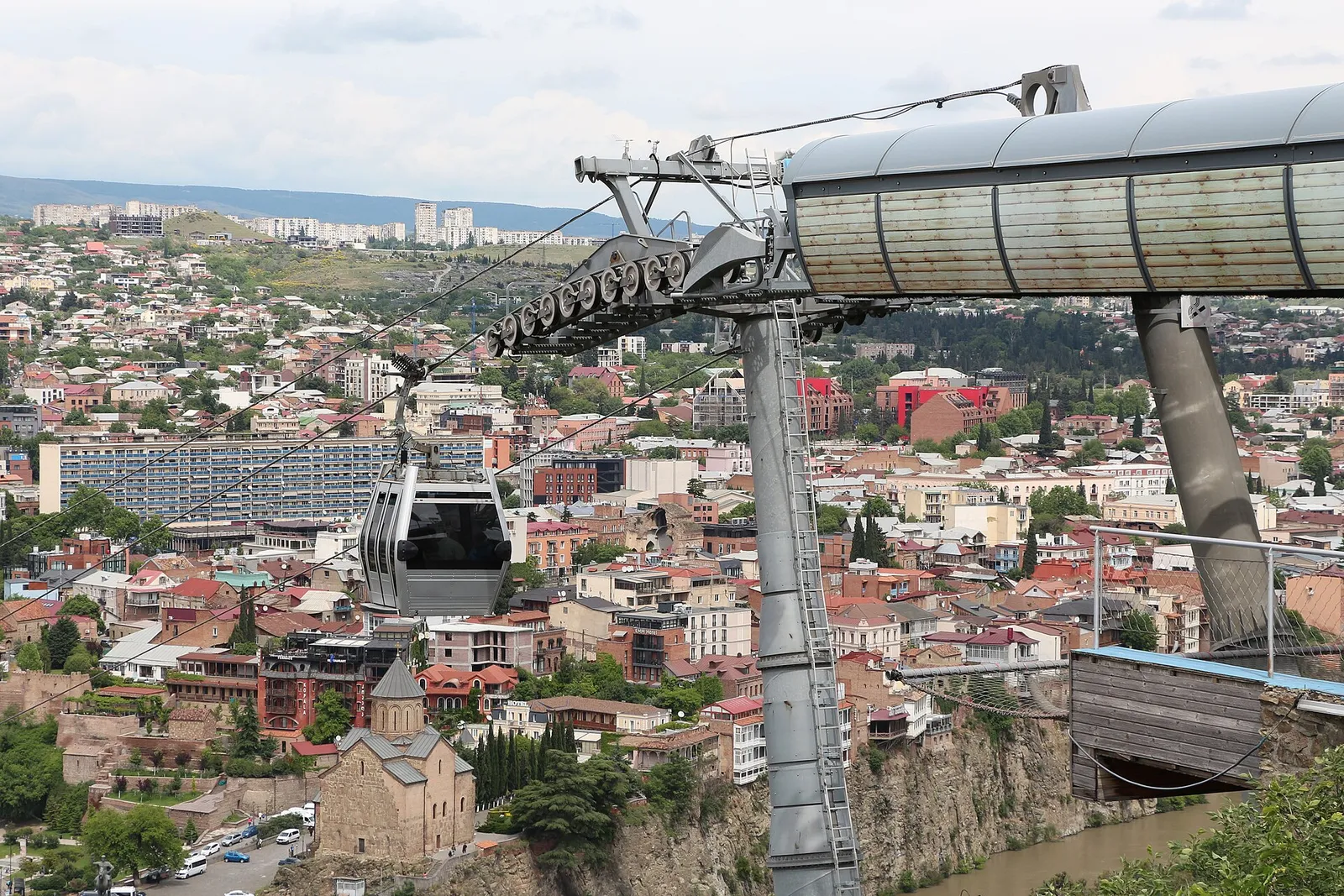 A cable car cabin crossing above the rooftops of Tbilisi, Georgia