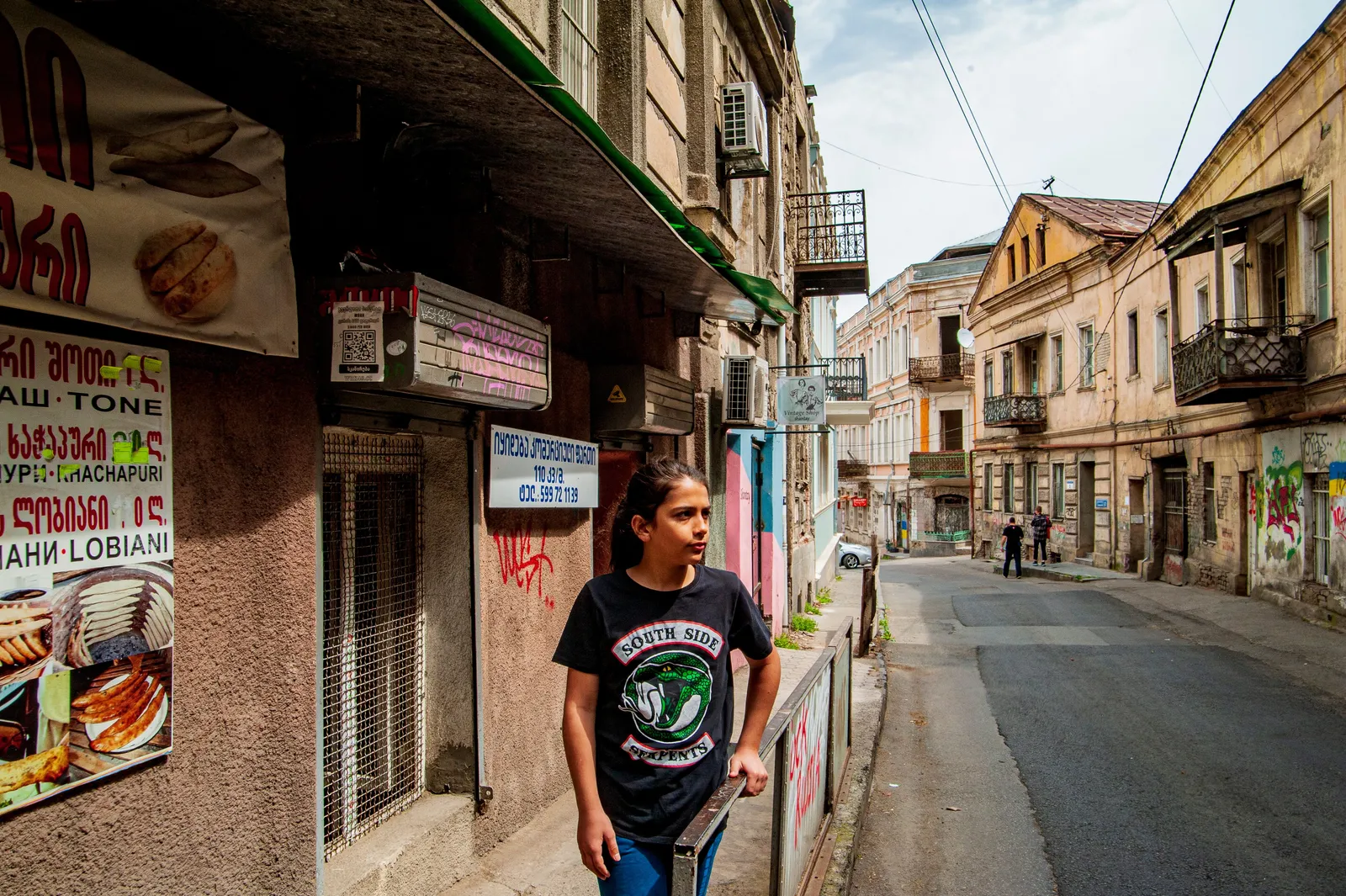Shop signs written in Georgian script along a side street in Tbilisi, Georgia