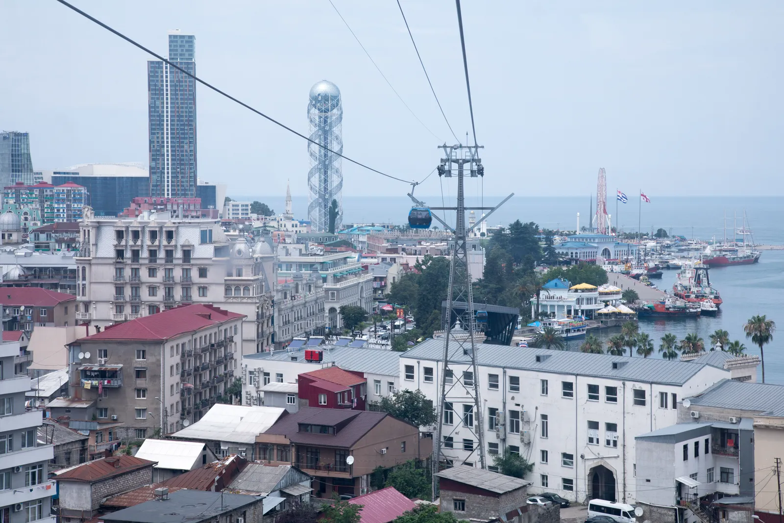 The rooftops of Batumi with a cable car line, the alphabet tower and the port on the Black Sea behind