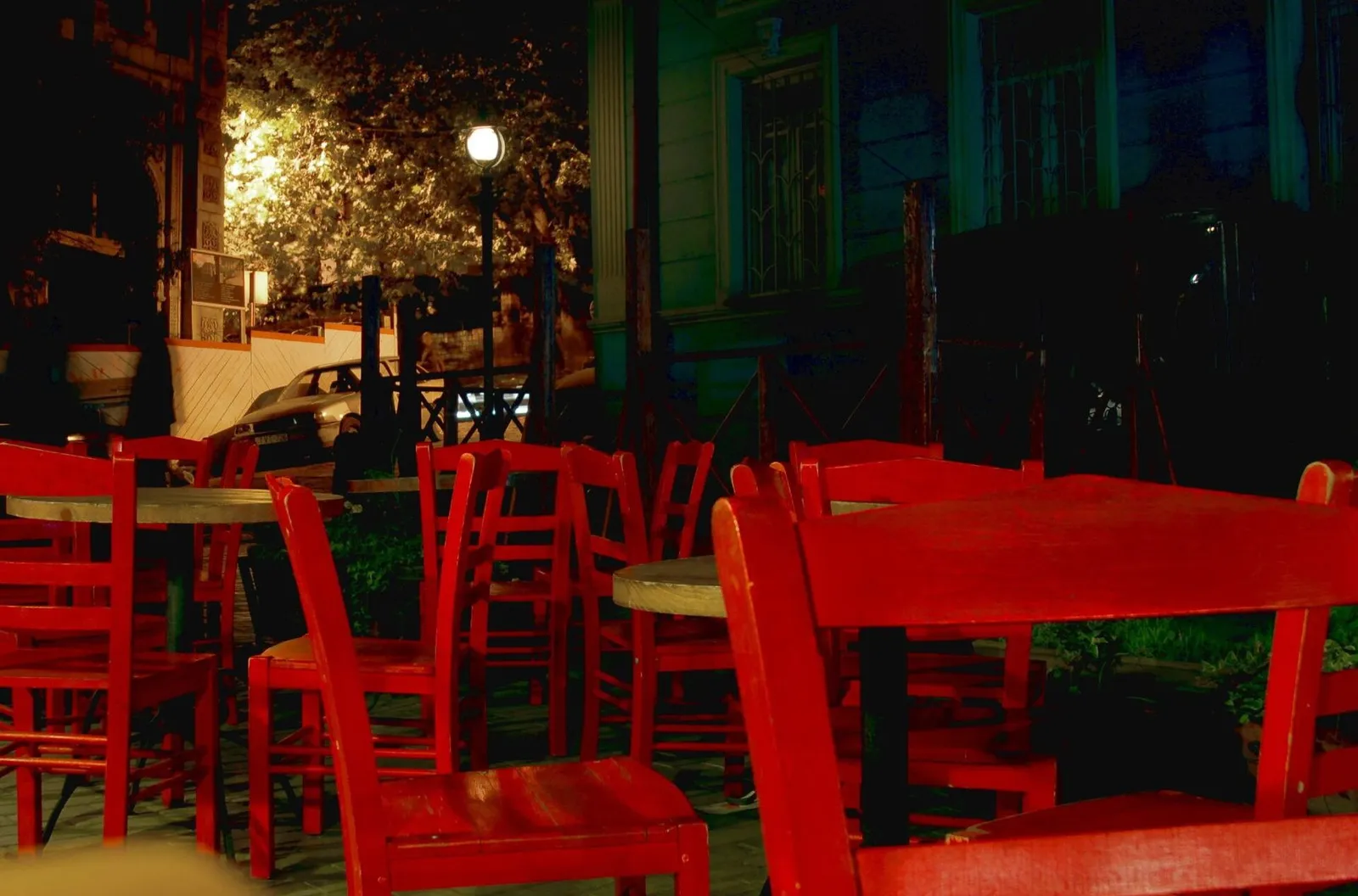 A restaurant terrace with red tables set for a meal in the evening in Georgia