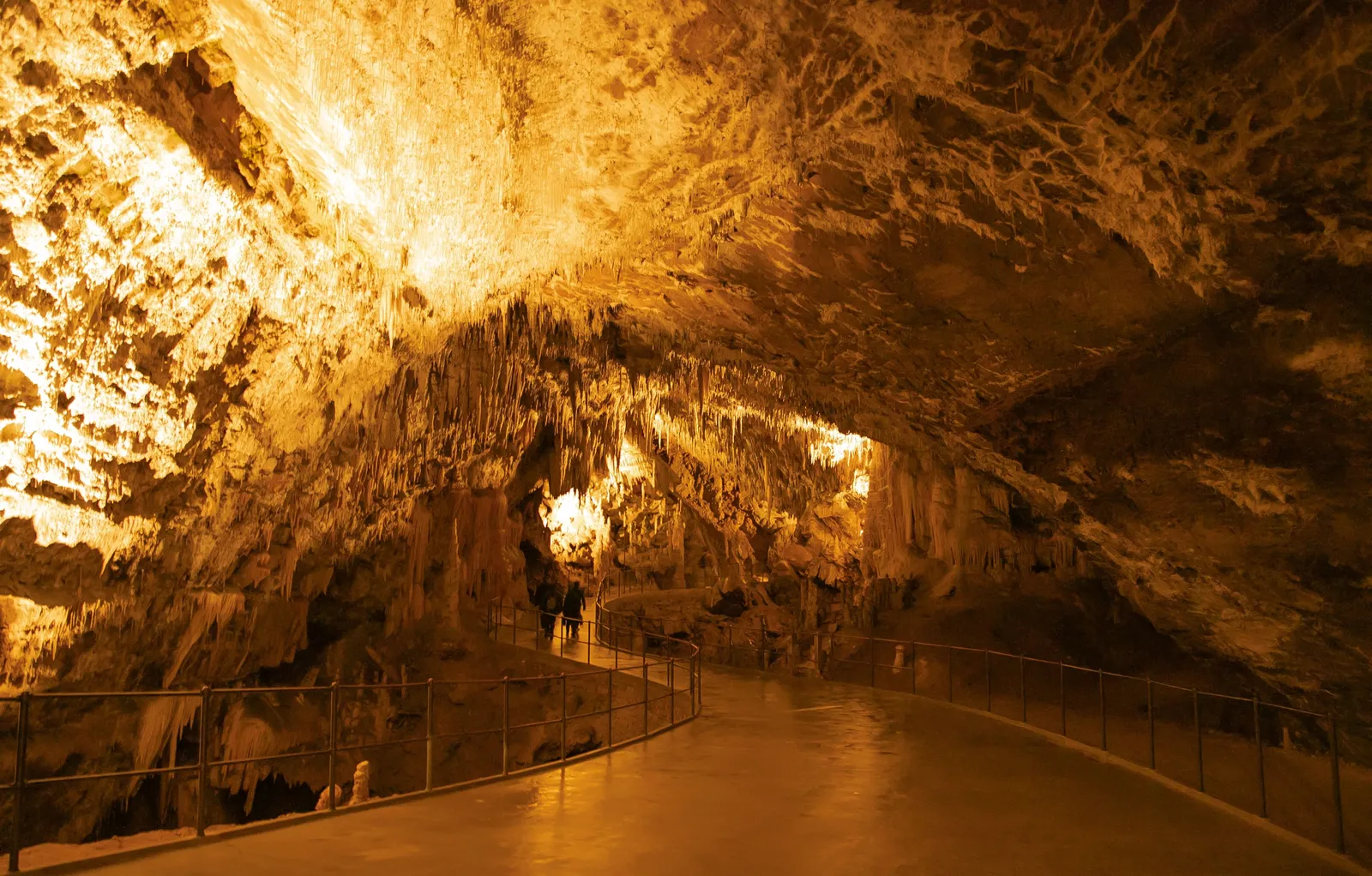 Lit stalactite chambers along the walkway inside Prometheus cave near Kutaisi