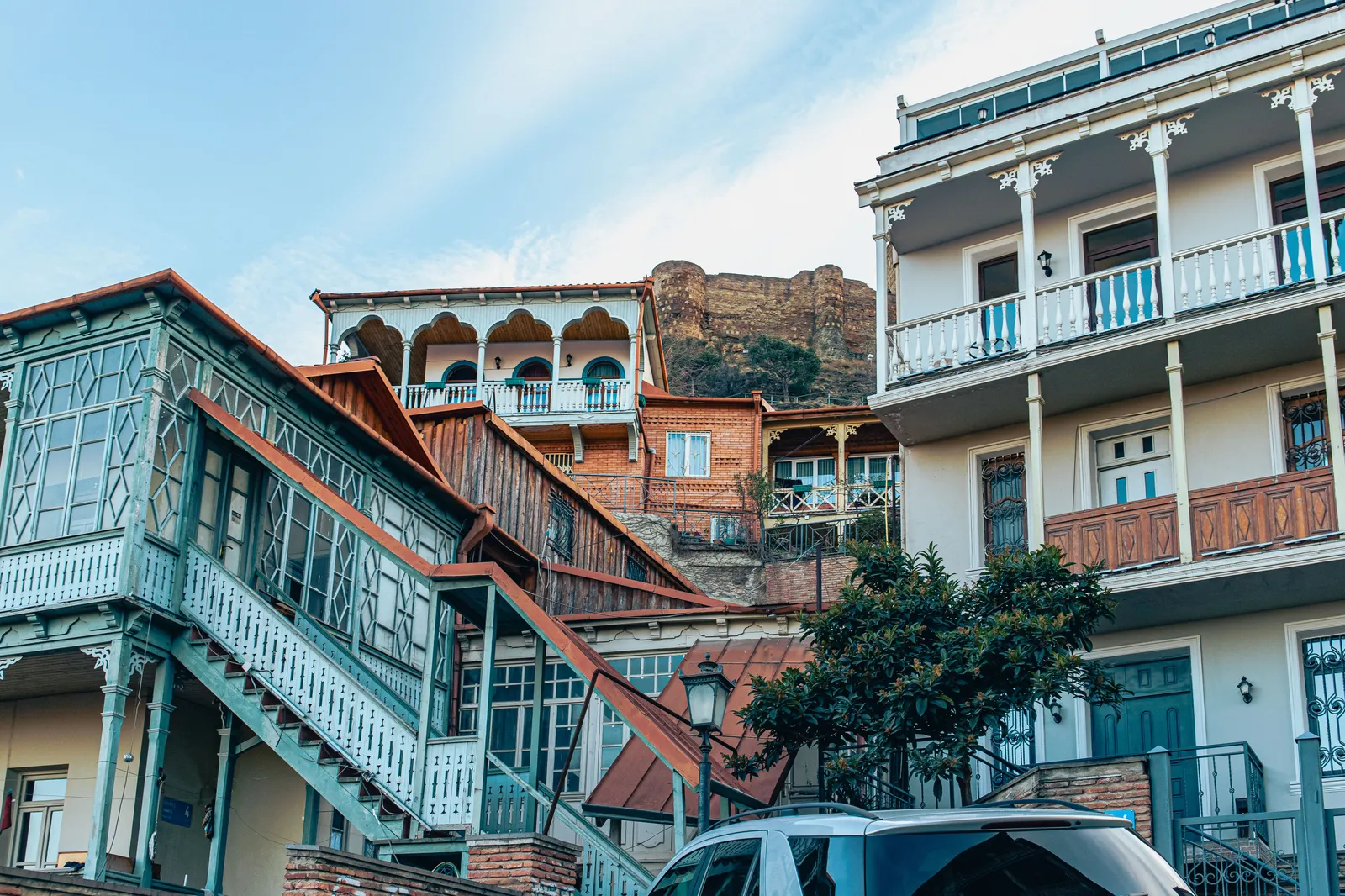 A narrow old town street with balconied houses in the historic quarter of a Georgian city