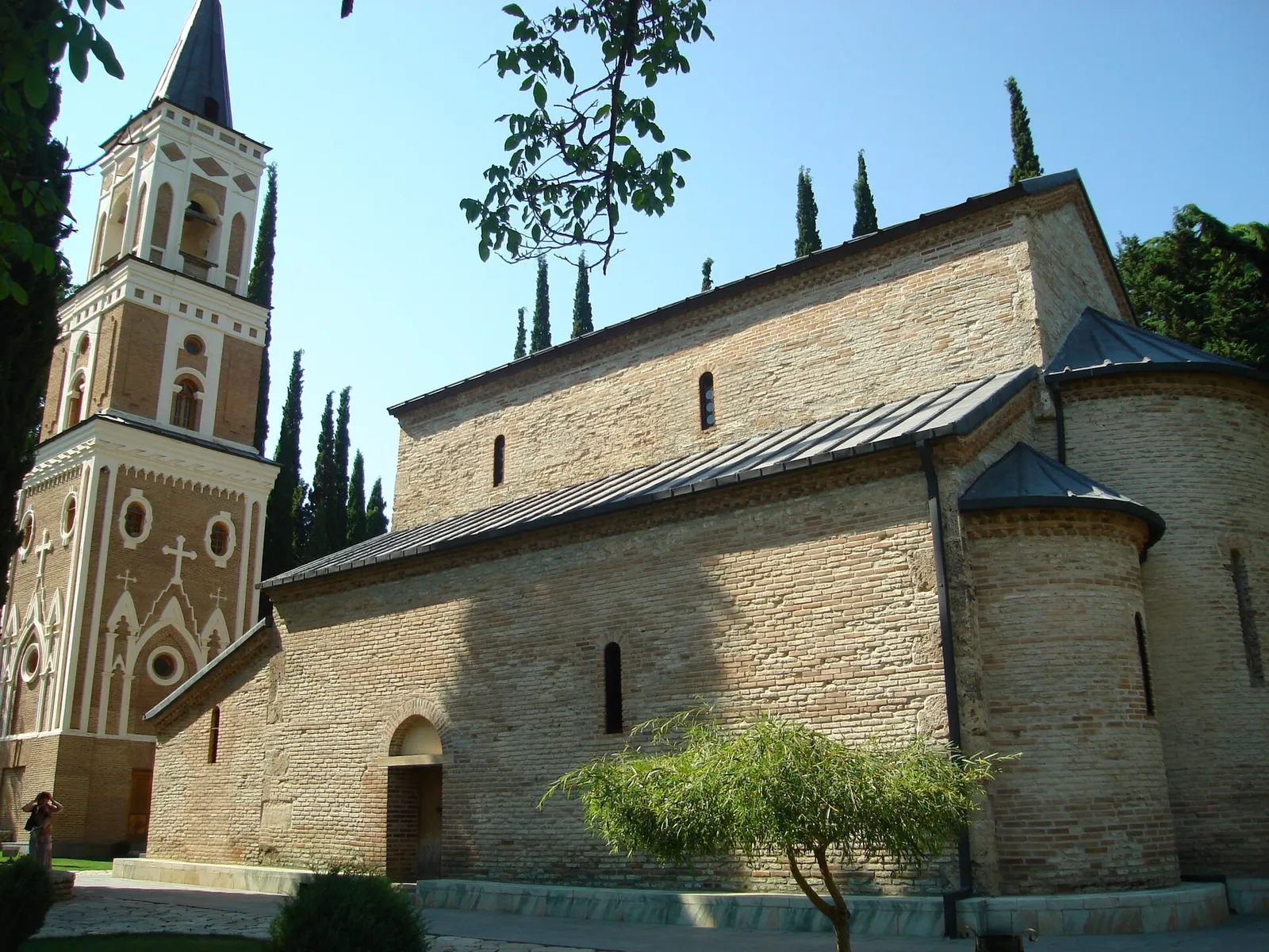 The church and bell tower of Bodbe monastery standing among cypresses near Sighnaghi