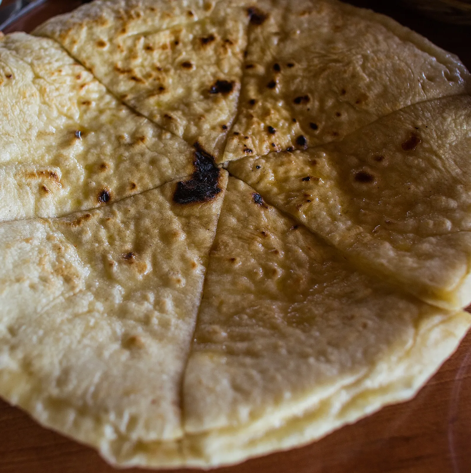 A round flat Imeruli khachapuri cut into wedges, Georgia