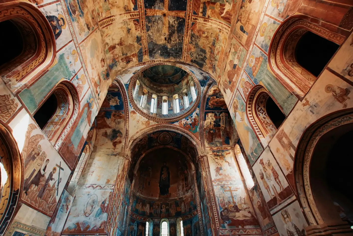 Interior of a Georgian monastery with medieval frescoes on stone walls