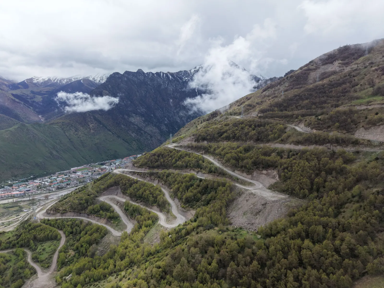 Mountain road in Georgia winding between green slopes