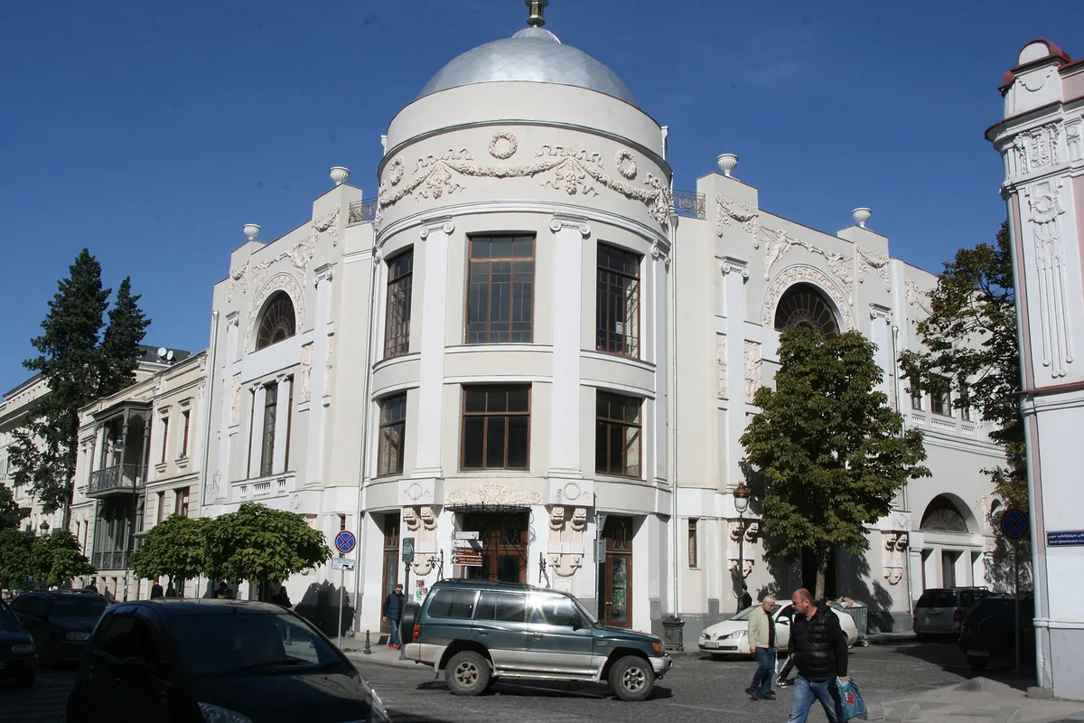 An ornate old town building behind trees