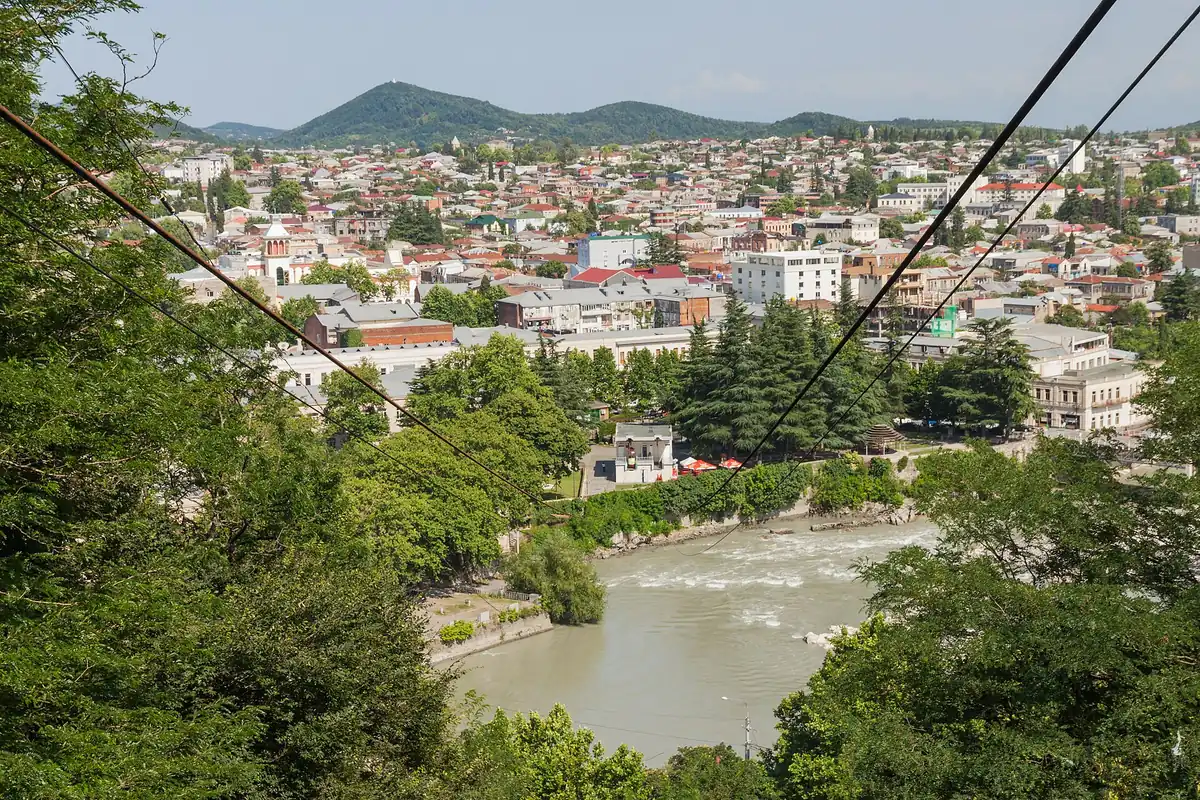 A town in a river valley seen through greenery