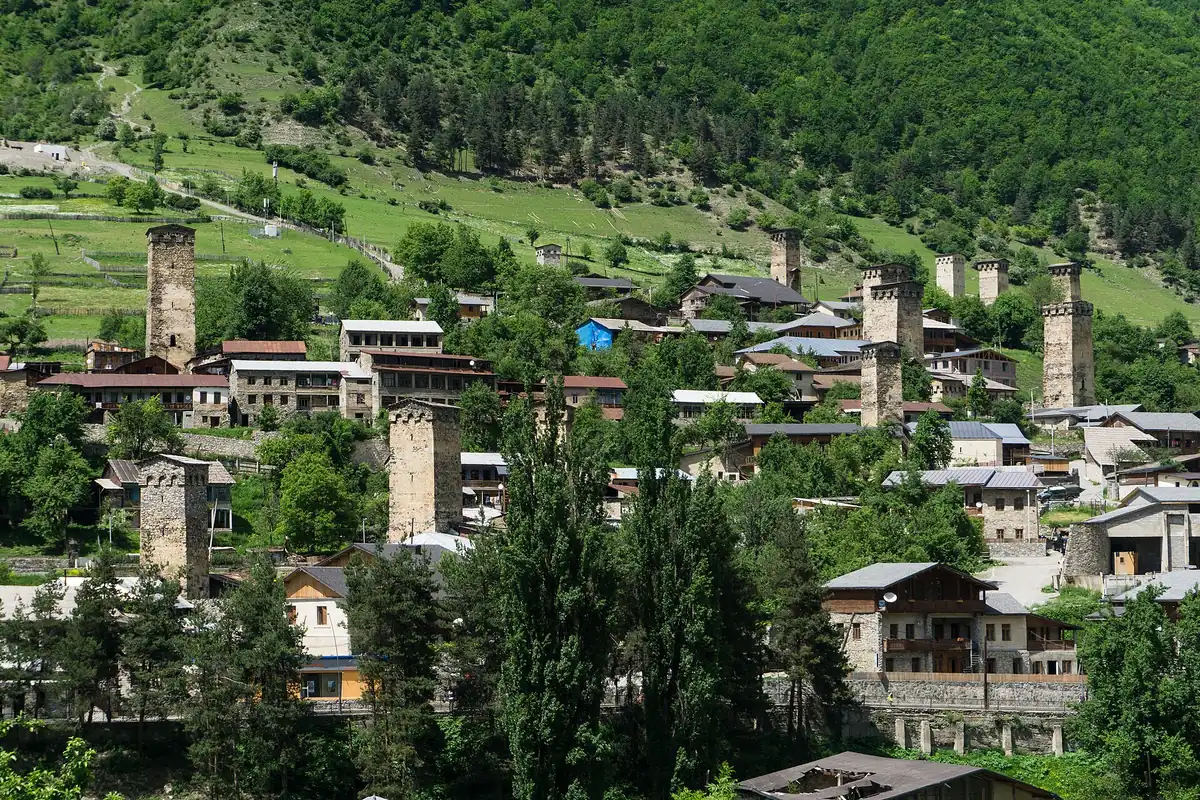 A mountain village with stone towers on a green slope