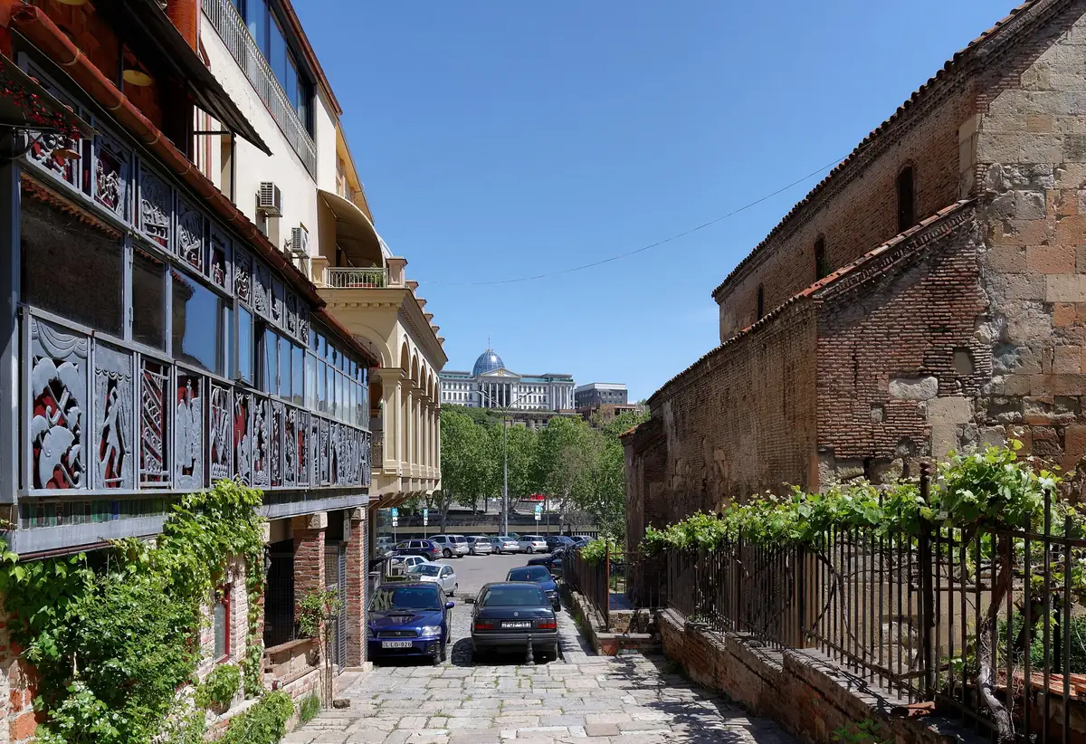 A lane with wooden balconies and climbing vines