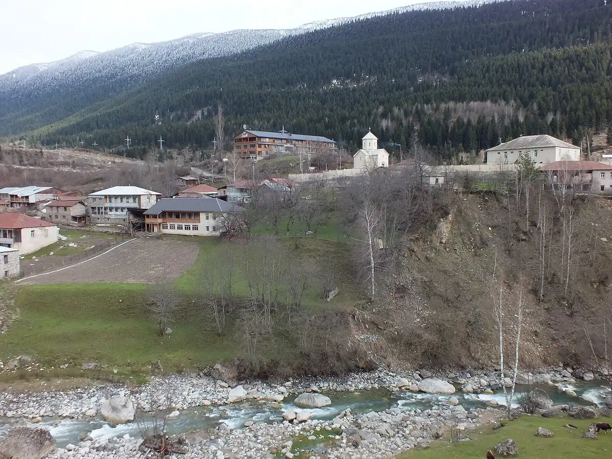 A village on a slope above a mountain river