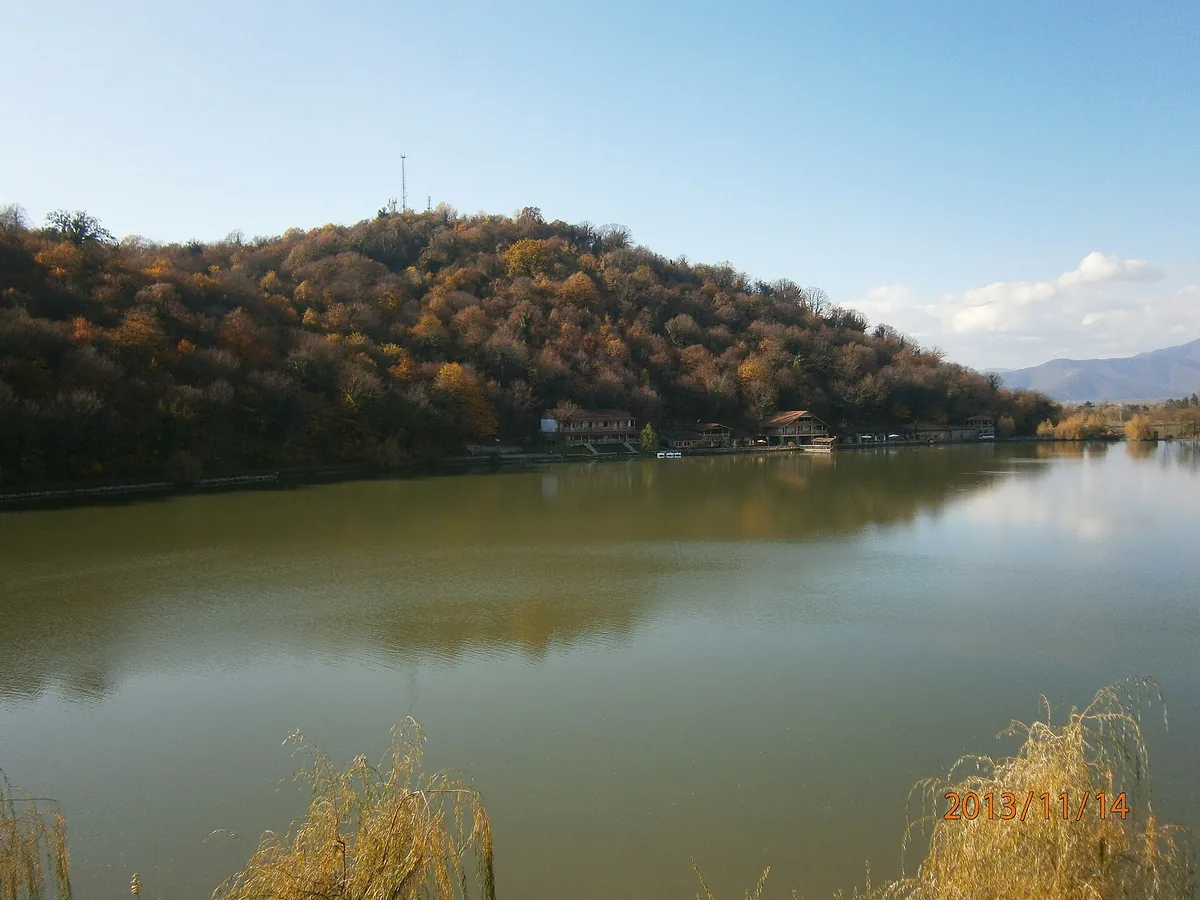 A calm lake ringed by hills in autumn colour