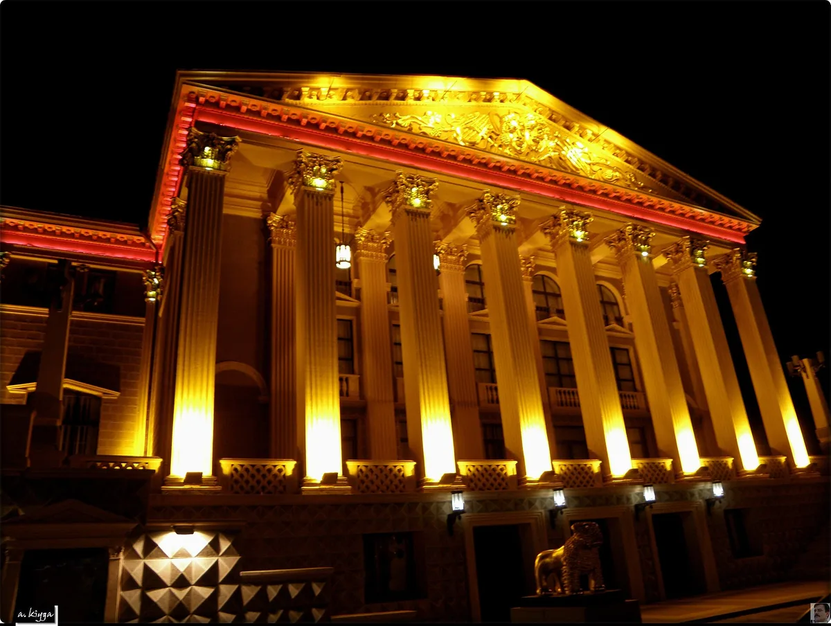 A classical building lit gold at night