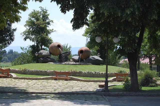 Two giant qvevri style clay jars on a lawn at the winery entrance
