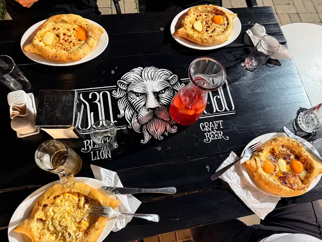 Four boat-shaped khachapuri with egg and butter on a dark table in the sun