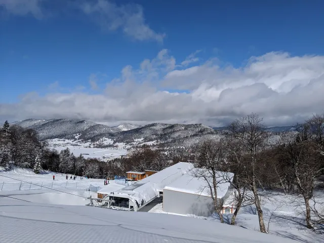 A snow covered mountain village with scattered houses and white slopes behind