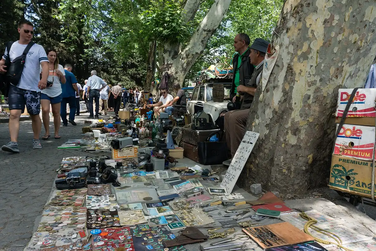A flea market along a pavement with browsers