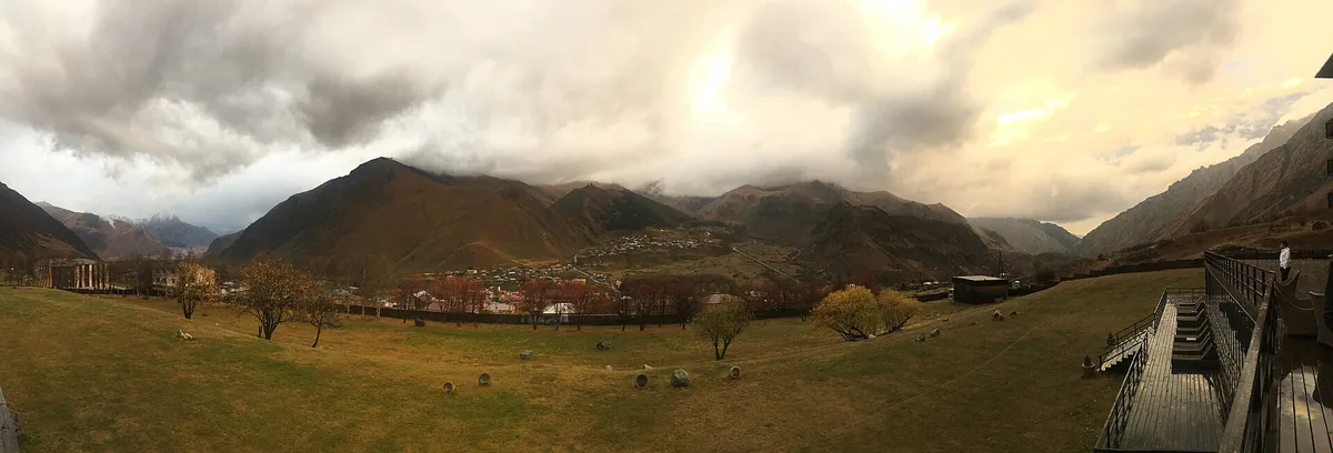 An open valley facing a clouded mountain ridge