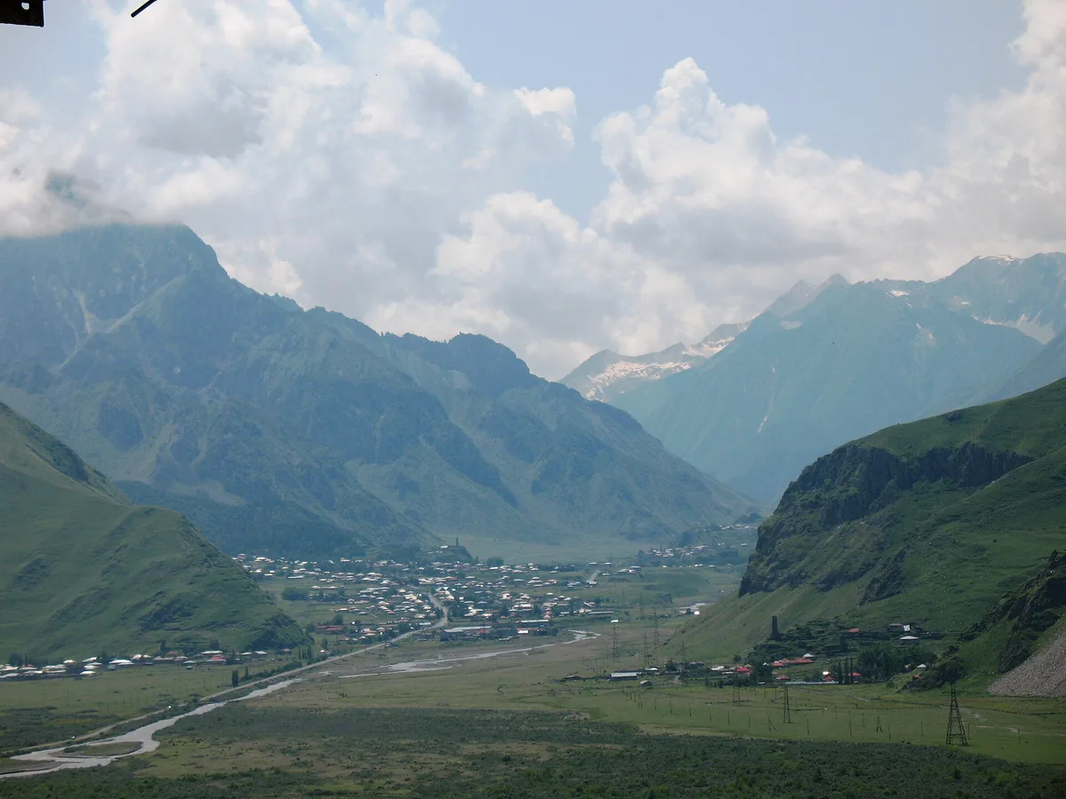 An open valley between green ridges