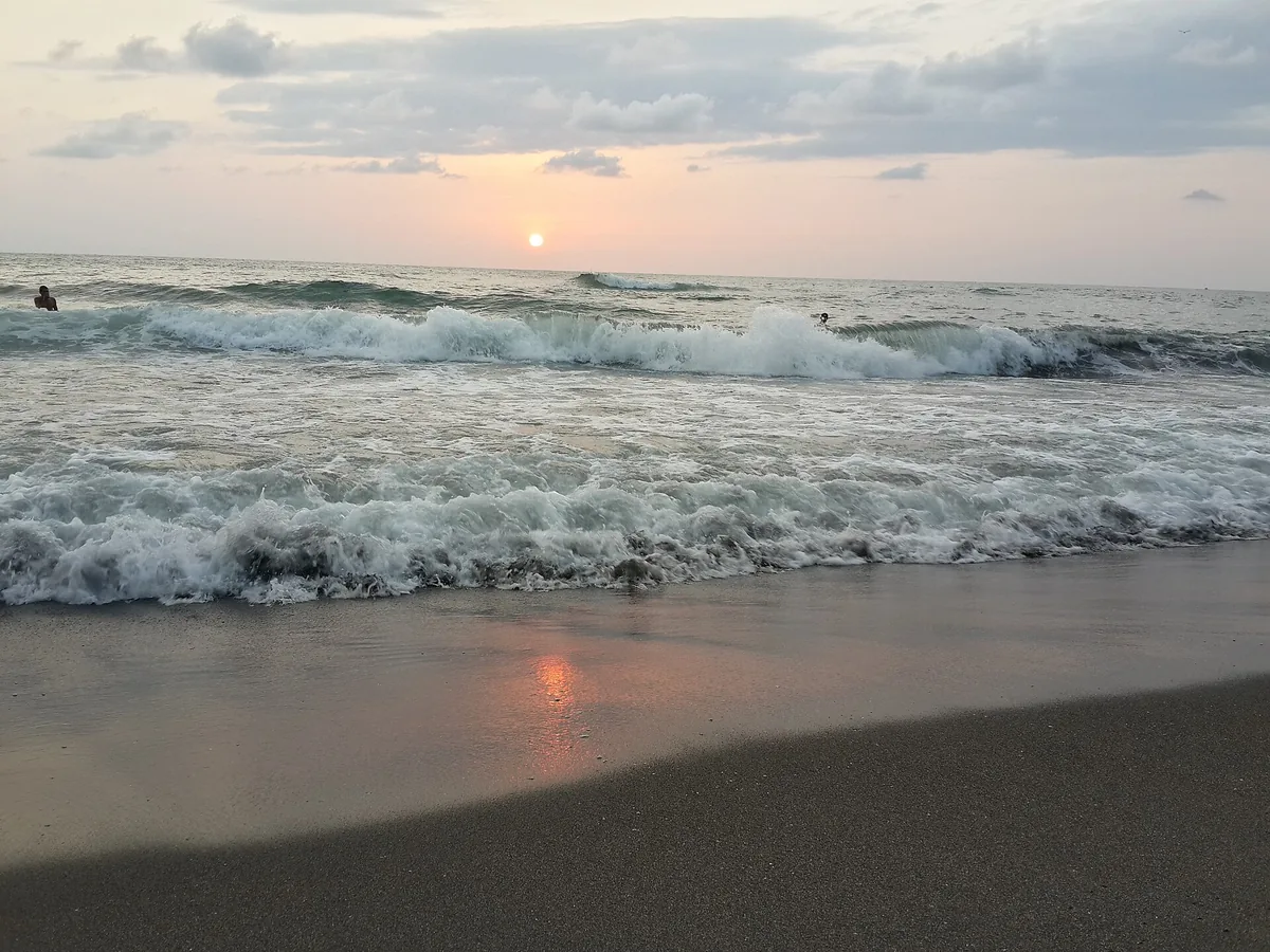 Waves breaking on the shore at sunset