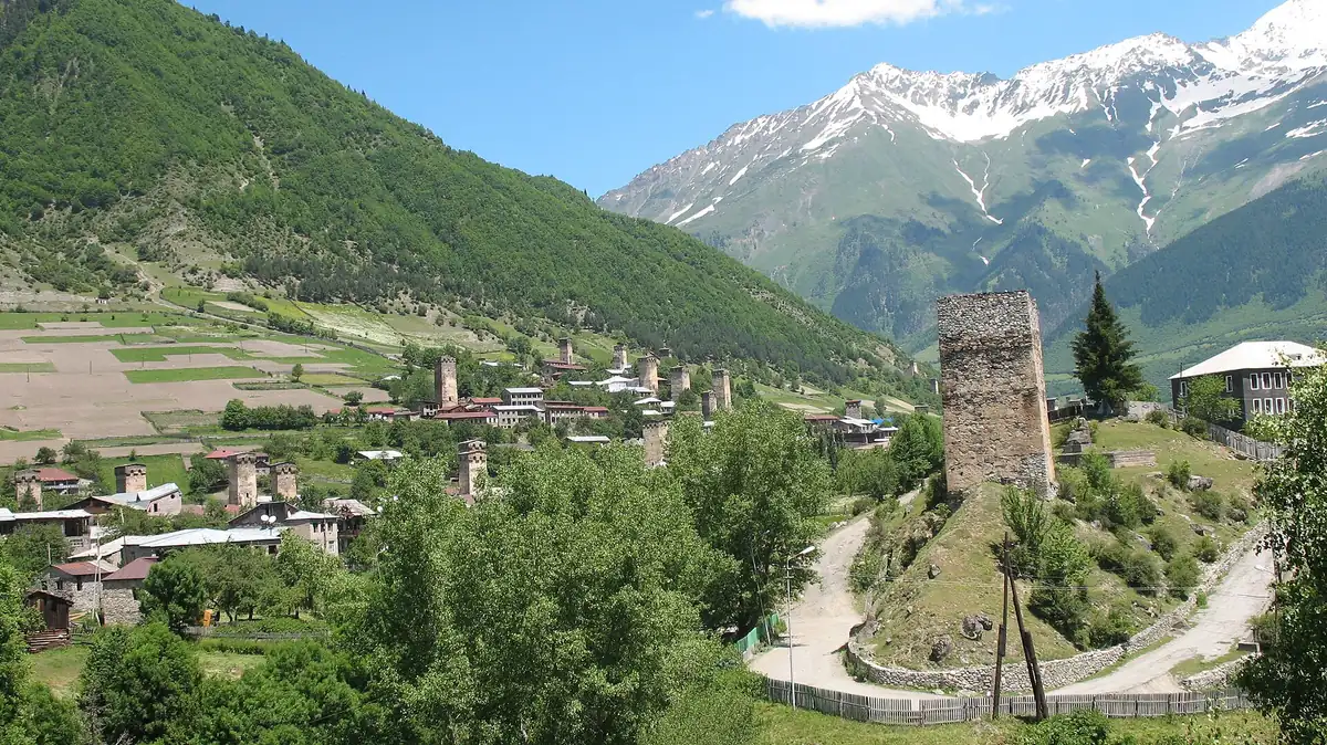 Stone towers in a village facing snow capped peaks
