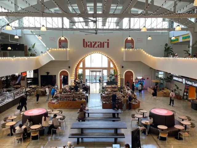 A view from above of a covered hall with an entrance arch, food stalls and seating areas
