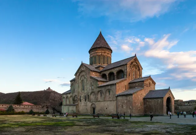 A large stone cathedral with a pointed dome tower inside its surrounding wall