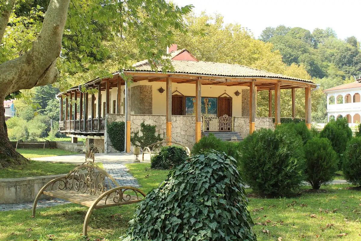 A covered wooden pavilion in a garden