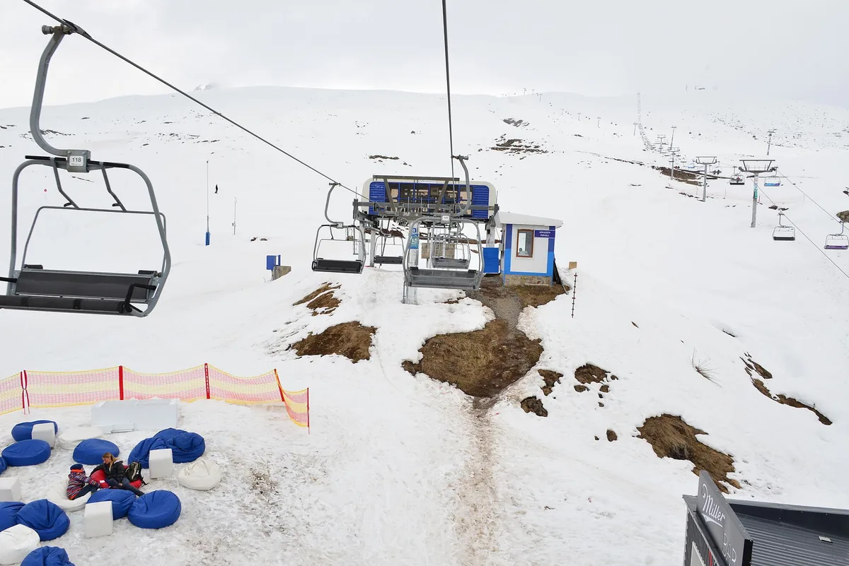 A chairlift above snow between mountains