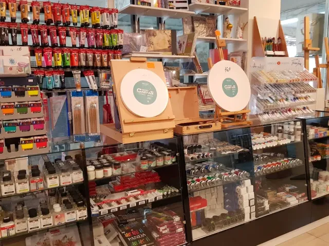 Shop shelves with paints, brushes, pencils and small easels in a display case
