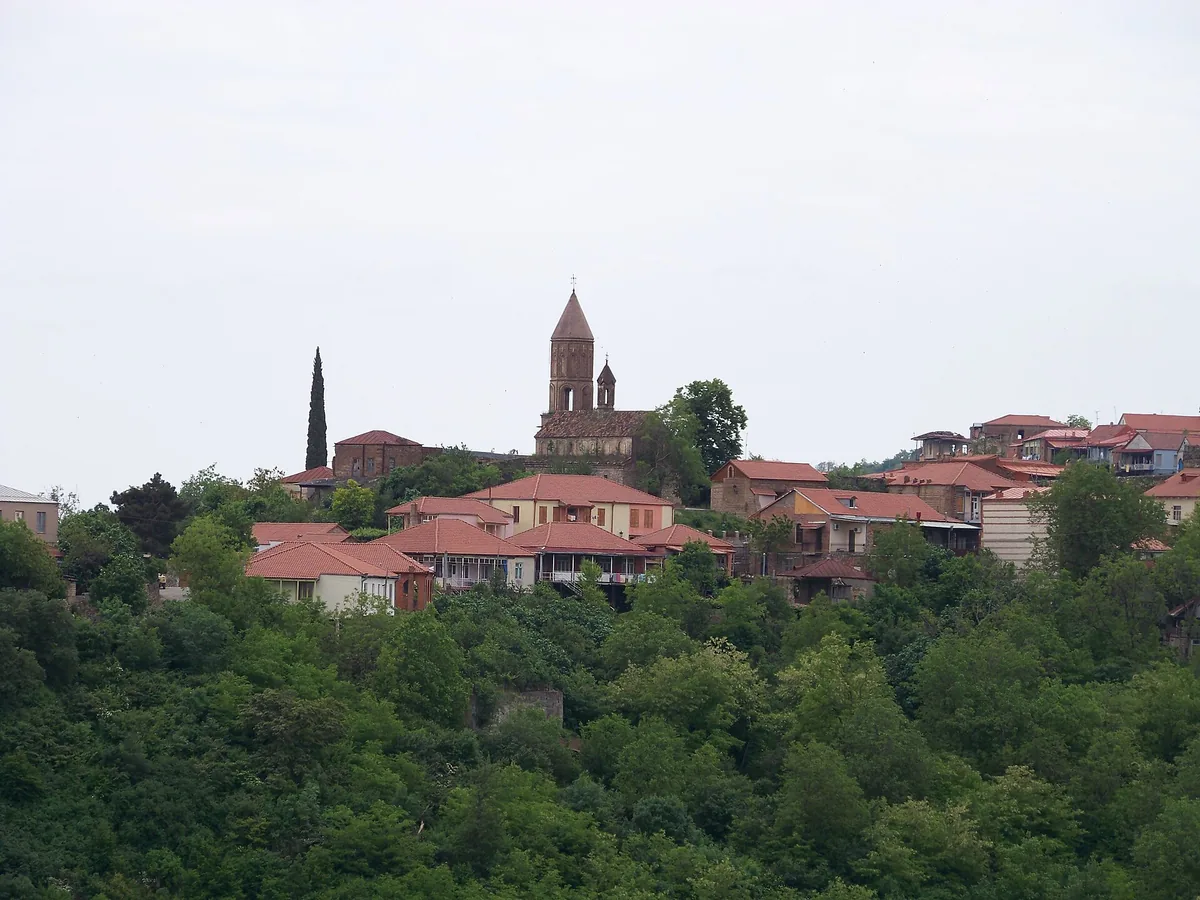 Red tiled roofs and a belltower on a hill