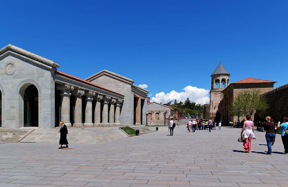 A paved forecourt before a church precinct