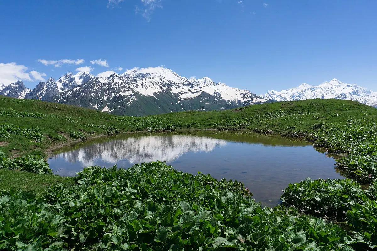 A mountain pool reflecting snow capped peaks