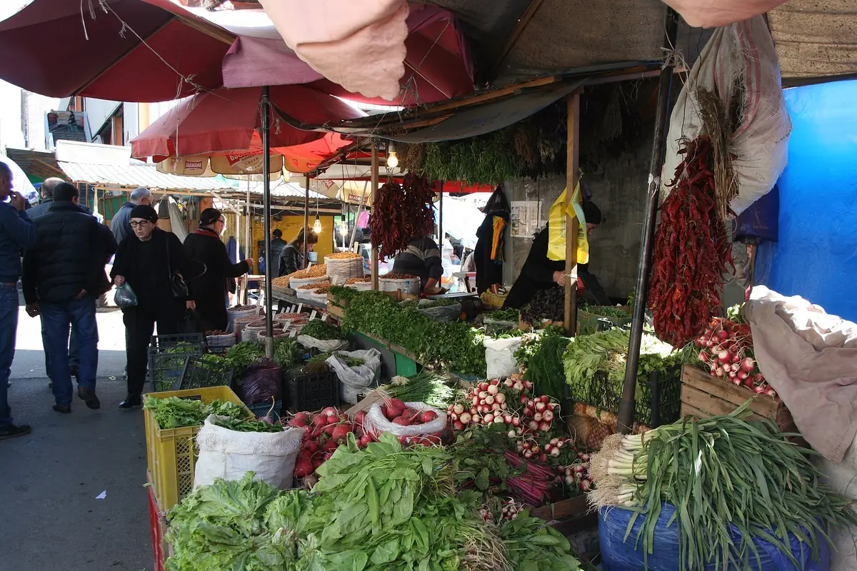 Vegetable stalls with parasols and shoppers