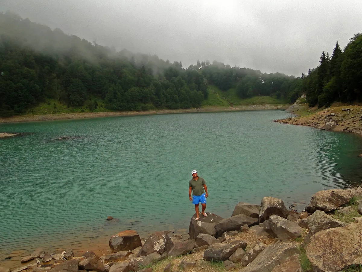 A green tinted lake between wooded slopes