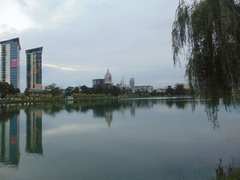 Nuri Lake in Batumi with willow branches in the foreground and the city towers reflected in the water