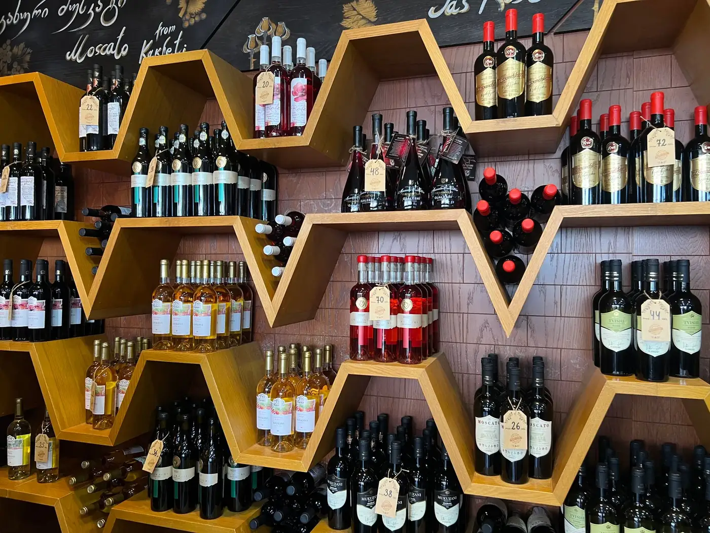 Georgian wines on hexagonal wooden shelves in a wine shop in Georgia