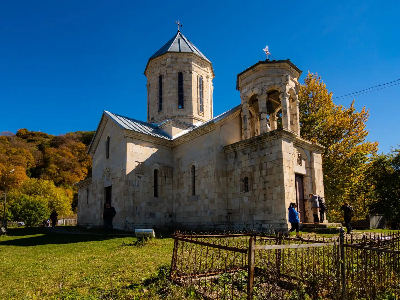 A small medieval Georgian stone church with a carved facade and a conical dome