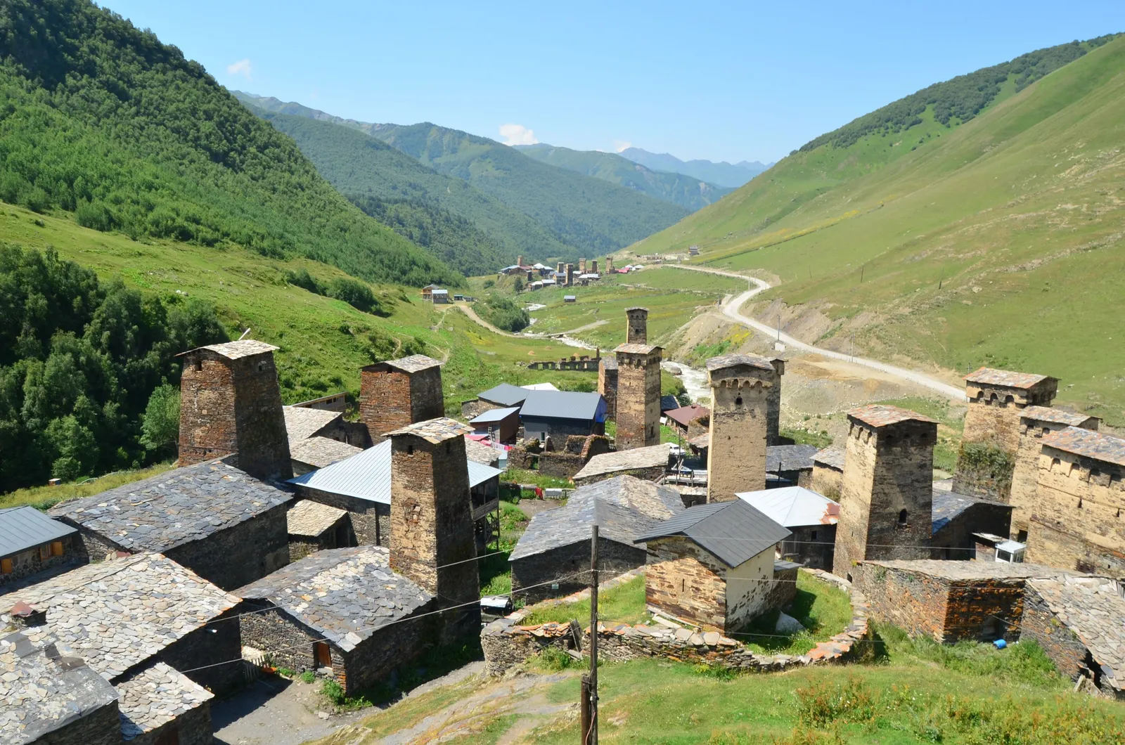 Mountain village in Svaneti with stone houses and towers on a green slope