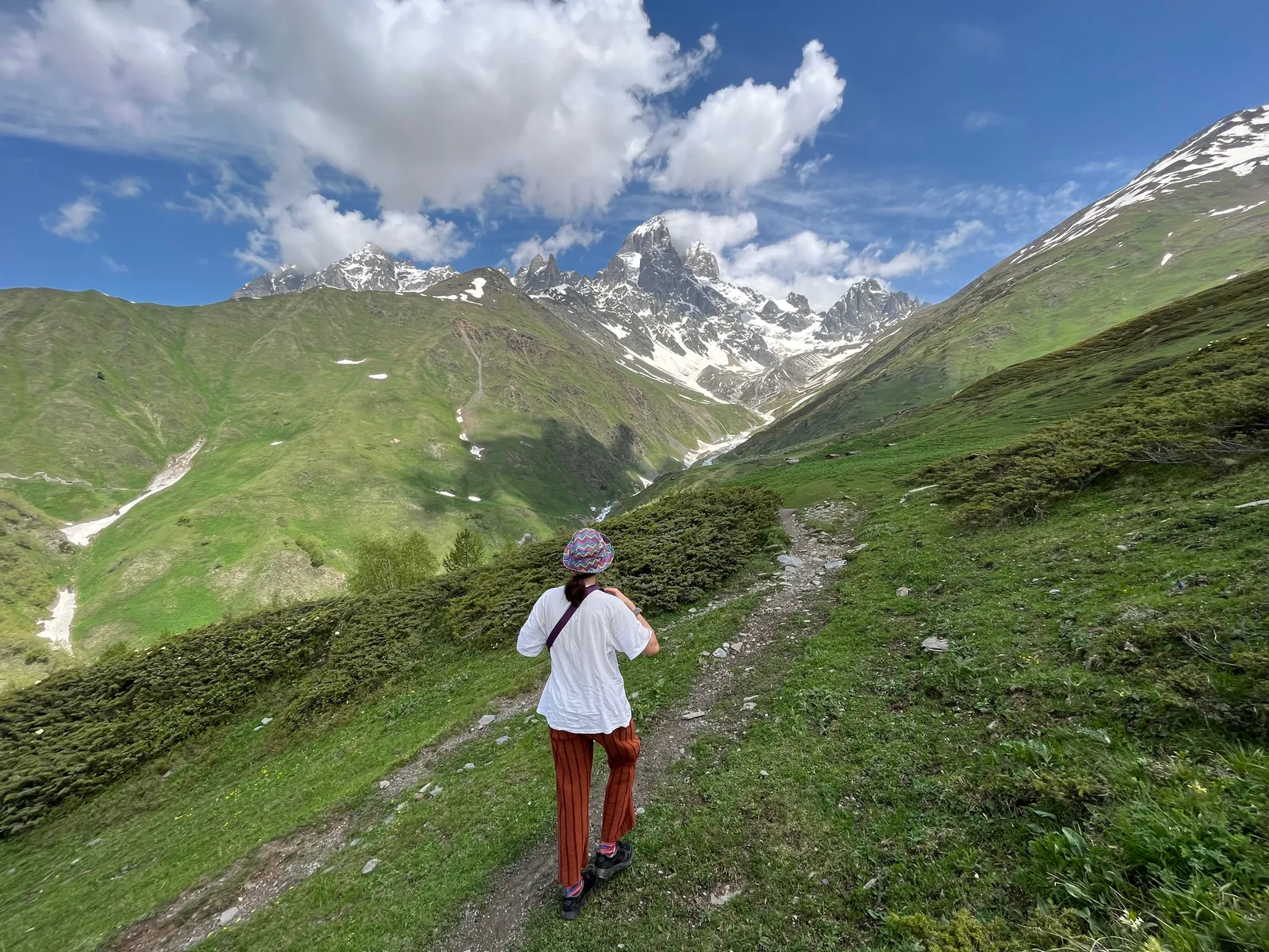 Walking trail above a valley in the high Caucasus with peaks ahead