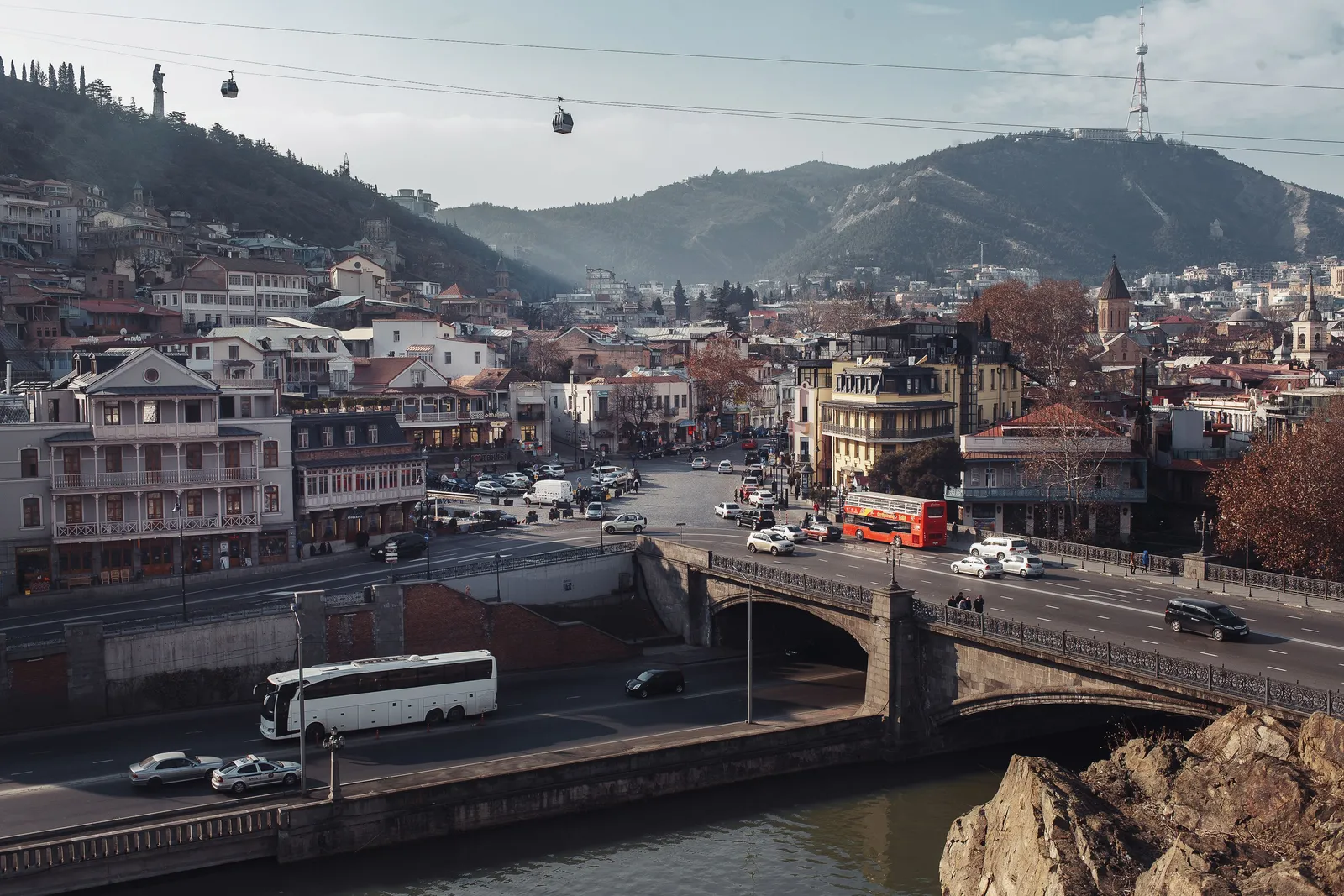 View along a road into central Tbilisi with hills behind the city
