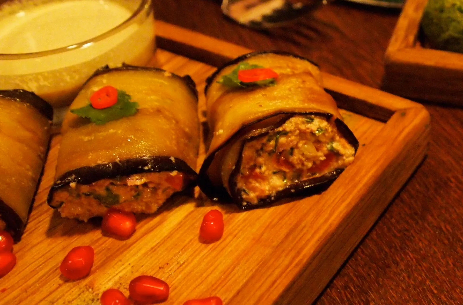 Rolls of fried aubergine filled with walnut paste on a wooden board, Georgia