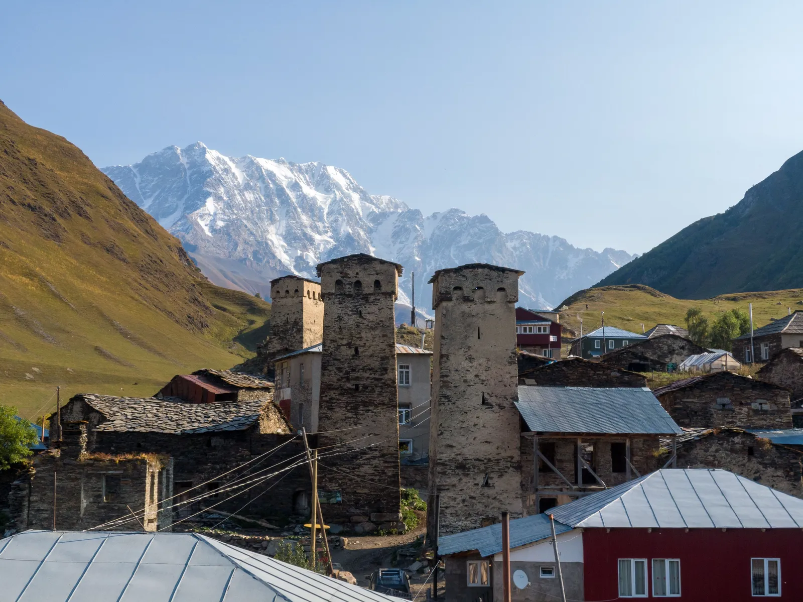 Guesthouse in a mountain village with the Caucasus range behind